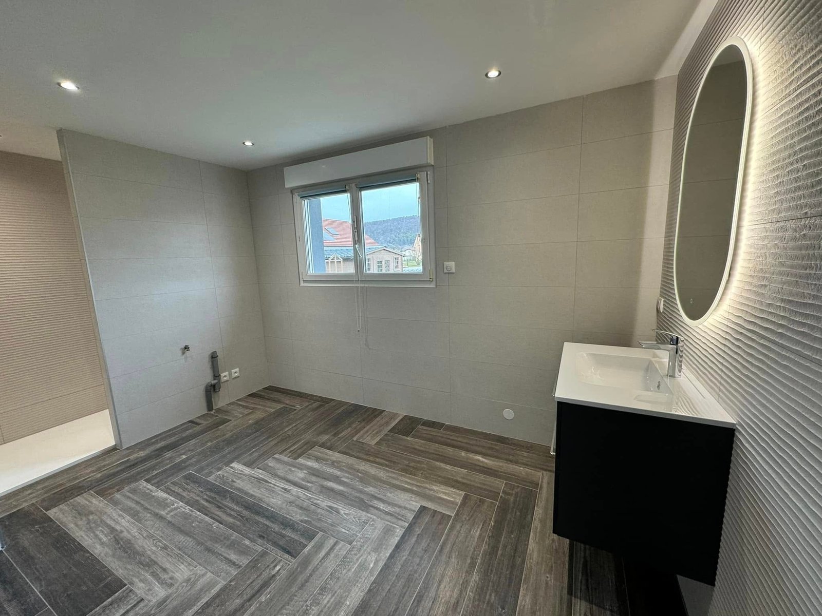 Colonne de rangement et meuble vasque suspendu dans une salle de bain moderne