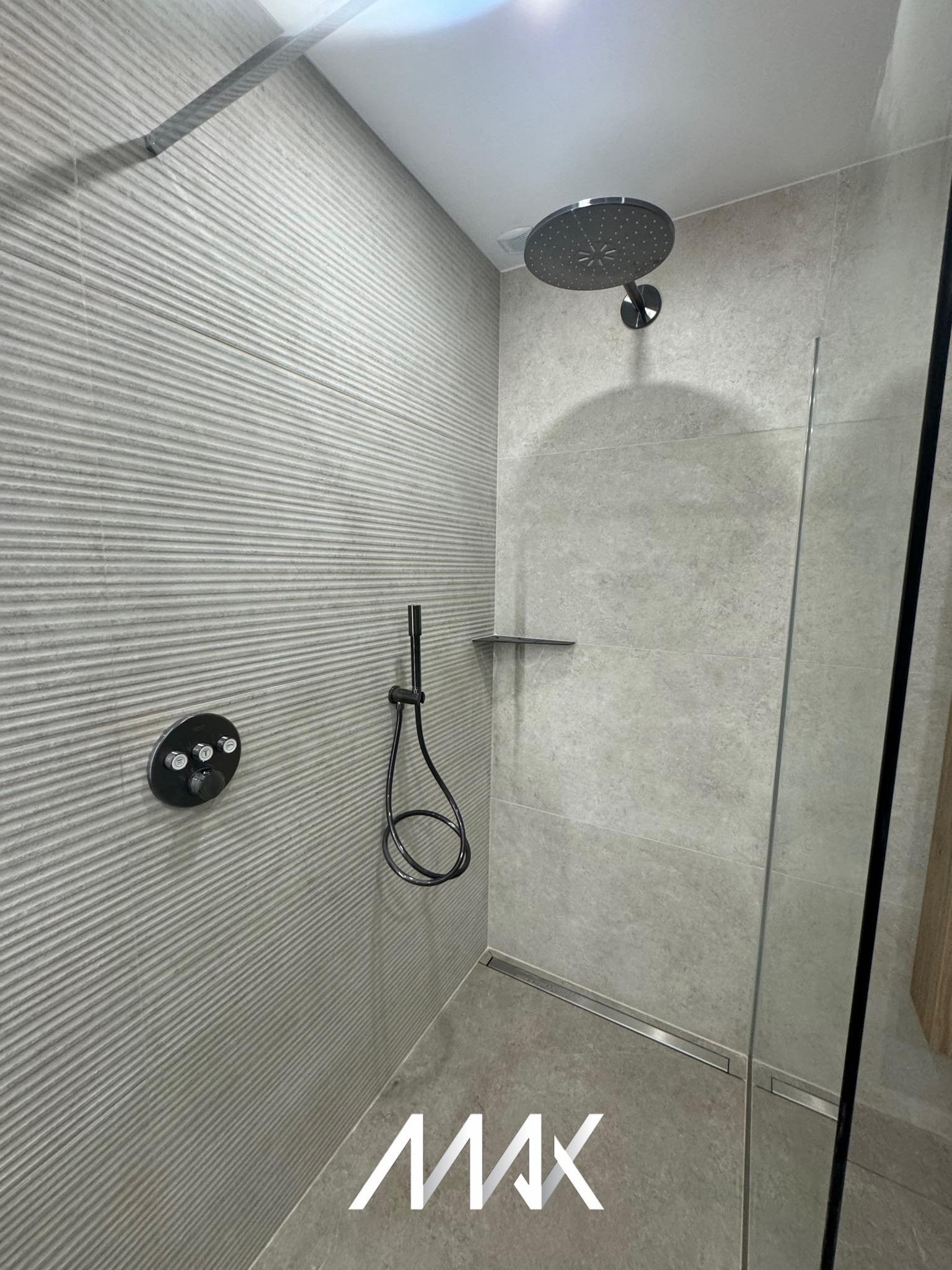 Douche moderne avec paroi vitrée remplaçant une ancienne baignoire